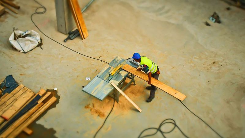 A construction worker cutting lumber on a job site